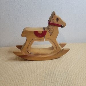 Vintage brown wooden rocking horse toy with red saddle